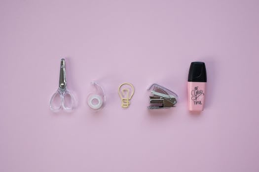 Top view of essential stationery items on a pastel background for office and school use.