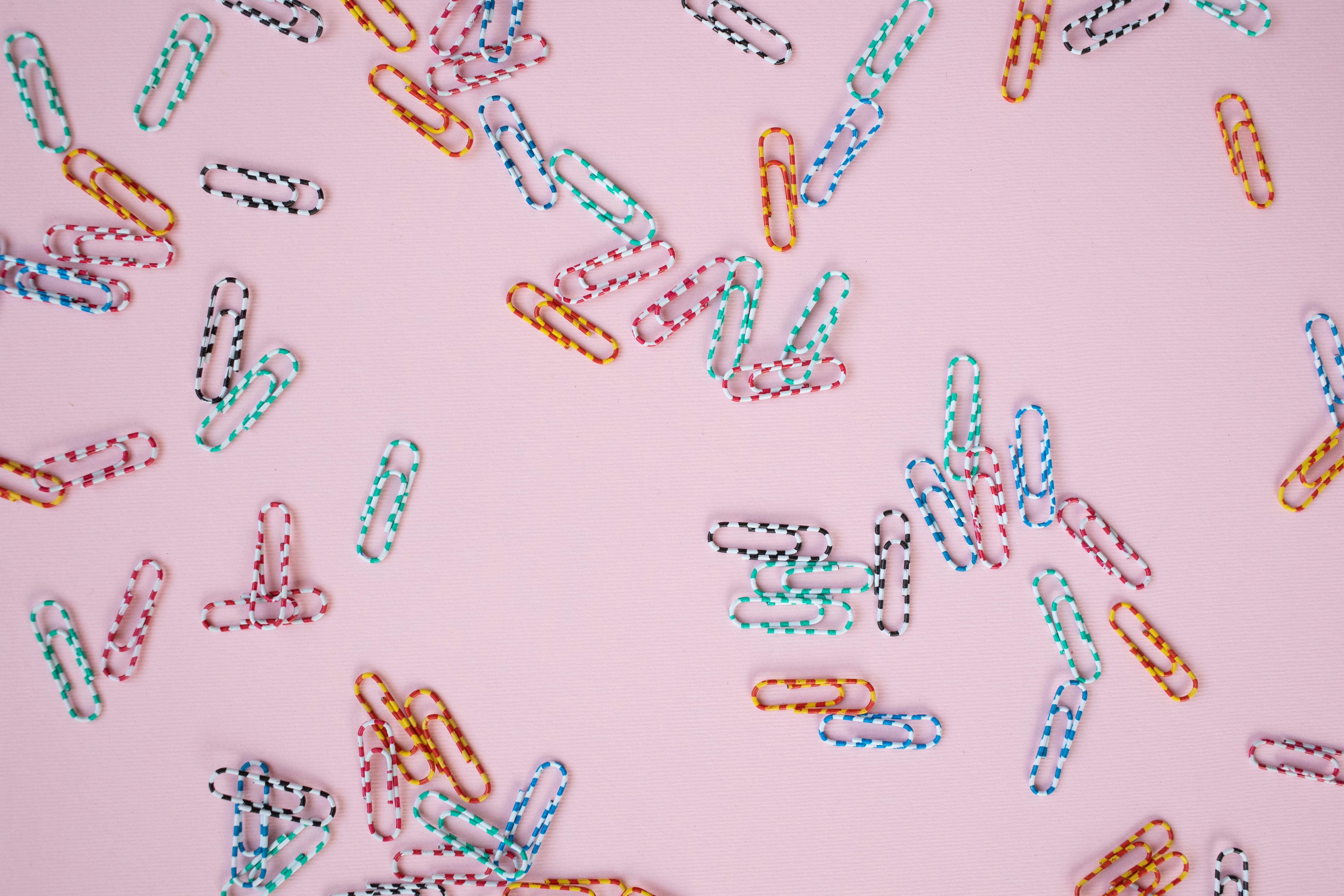 colorful paper clips on pink background