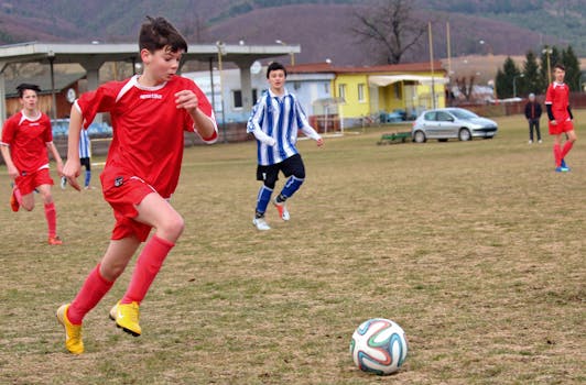 Boys playing a competitive soccer match on an outdoor field, showcasing action and teamwork.