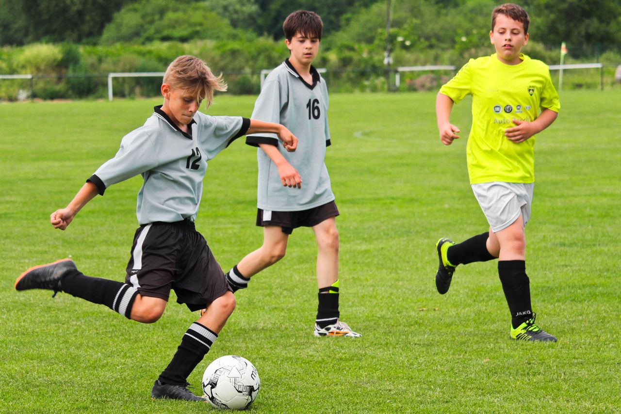 young boys engage in a thrilling soccer match on a green field showcas