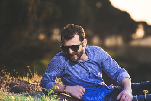 Free Selective Focus Photography of Man Lying on Green Grass Stock Photo