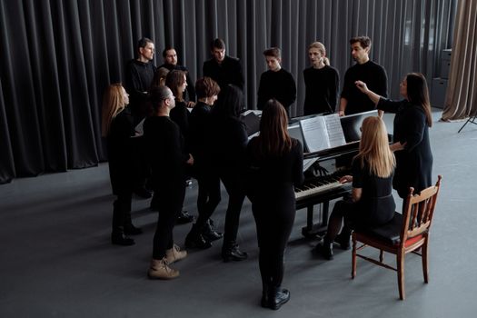 Group of People Standing around a Piano