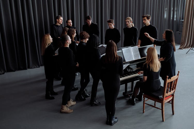 Group Of People Standing Around A Piano