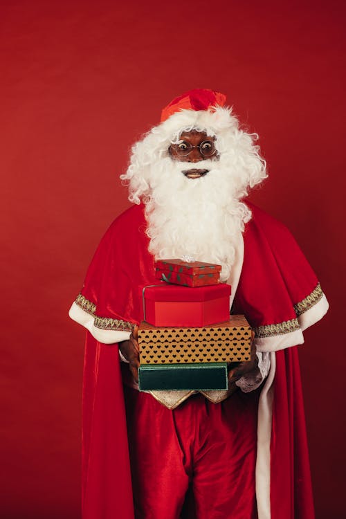 Santa Claus Holding Christmas Presents on Red Background
