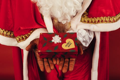 Persona Vestida Con Traje De Santa Claus Sosteniendo Un Regalo De Navidad