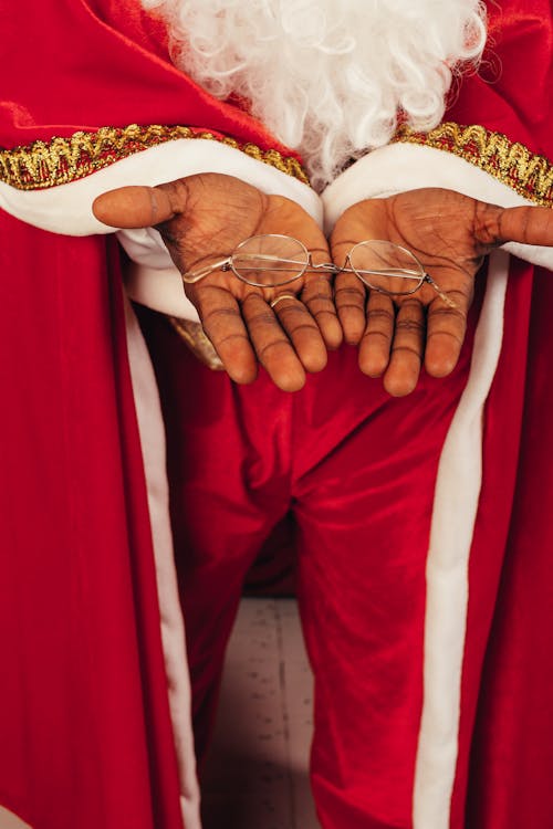 Person Wearing Santa Claus Outfit While Holding an Eyeglasses