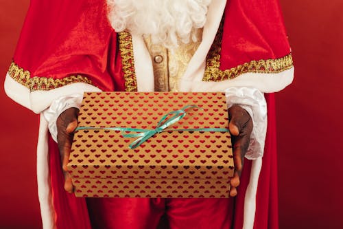 Free Person Wearing Santa Claus Outfit While Holding Christmas Gift Stock Photo