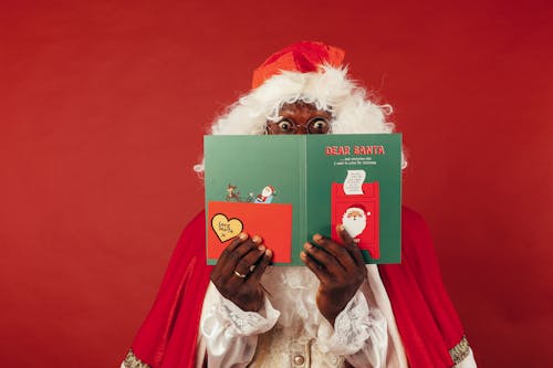 Free A Christmas Card Covering a Santa Claus' Face Stock Photo