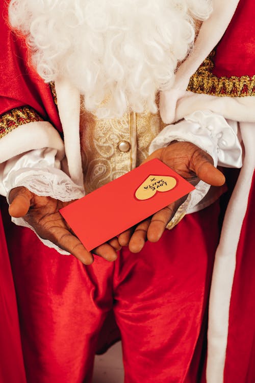 Person Wearing Santa Claus Outfit While Holding Christmas Letter