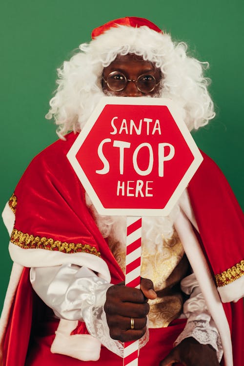 Santa Claus Holding Red and White Stop Signage