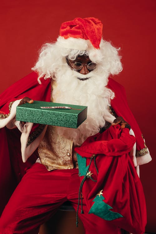 Free Santa Claus Holding Green Christmas Present Stock Photo