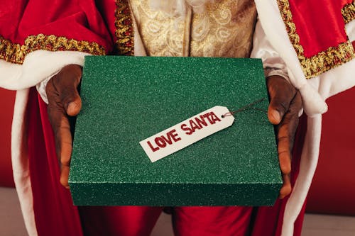 Person In Santa Outfit Holding A Gift Box