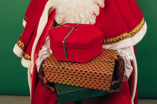 Person In Santa Claus Outfit Holding Gifts