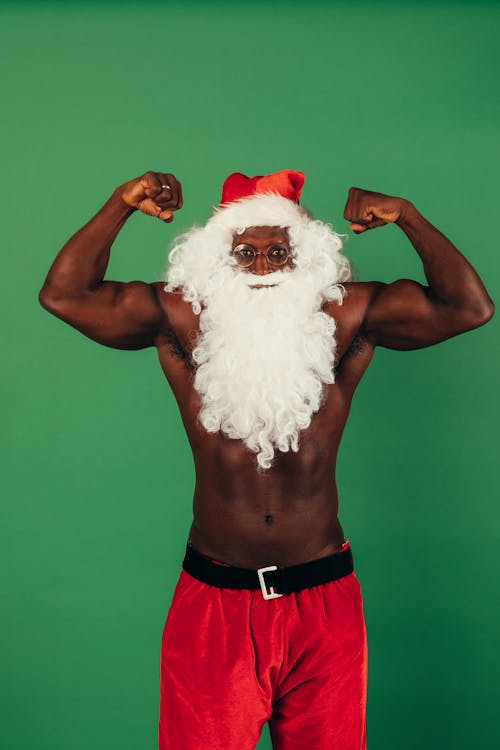 Shirtless Man In Santa Outfit Flexing His Muscles