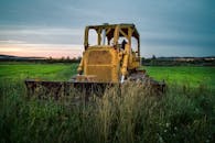 Tractor with in grassy field in countryside