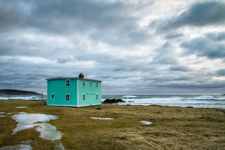 House Facade On Shore Against Stormy Sea