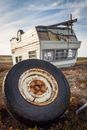 Caravan and rusty wheel after accident on land in countryside