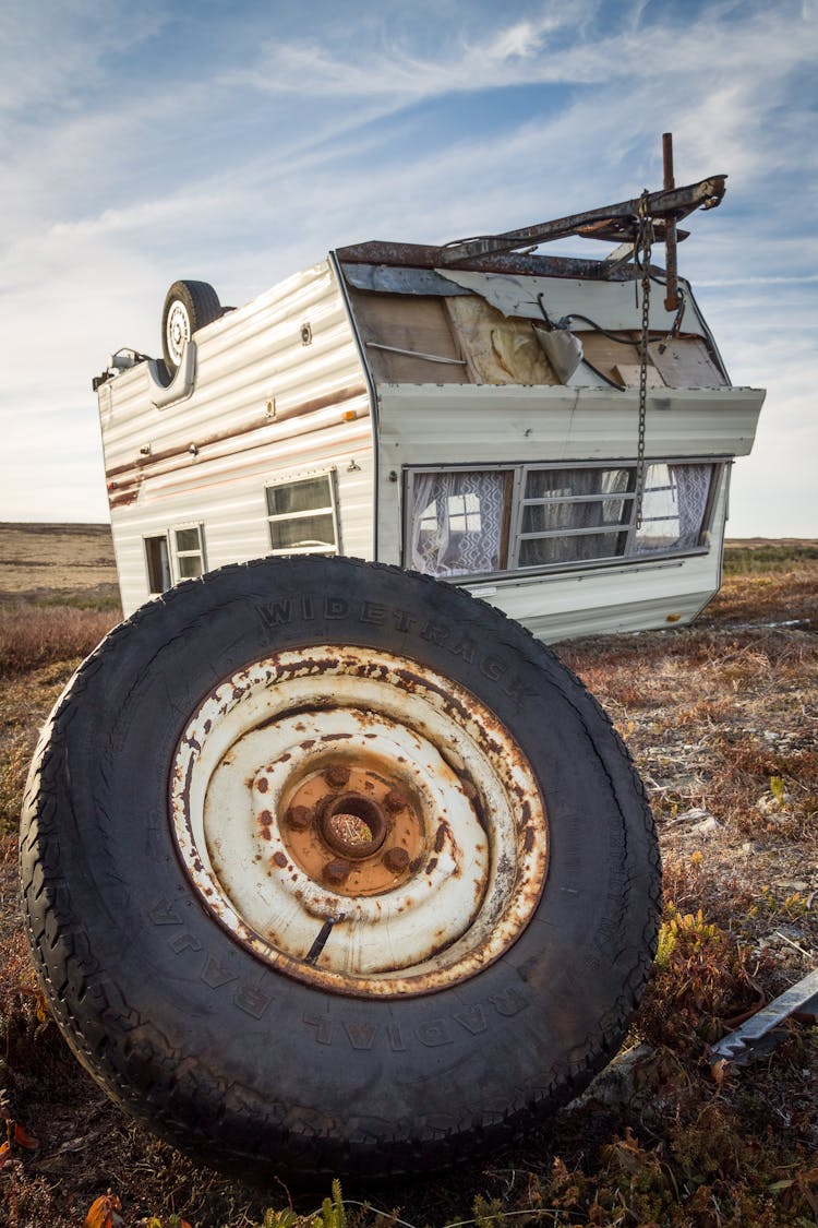 Caravan And Rusty Wheel After Accident On Land In Countryside