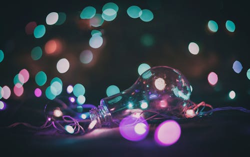 Free Close-Up Photo of a Lightbulb with Bokeh Lights Behind Stock Photo