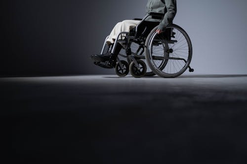 Free A Person Wearing Black Boots on a Wheelchair Stock Photo