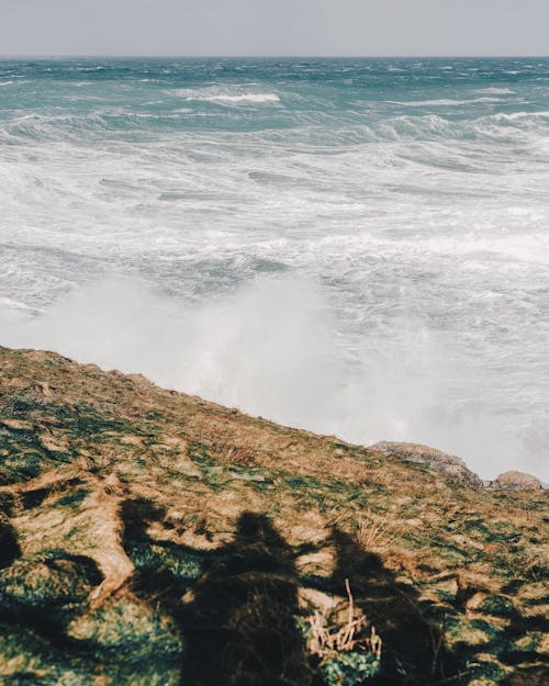 Endless stormy sea crashing over rocky cliff