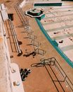 High angle of steps with metal railings near empty pool with dirty spots near waterless fountain in sunny summer day in street