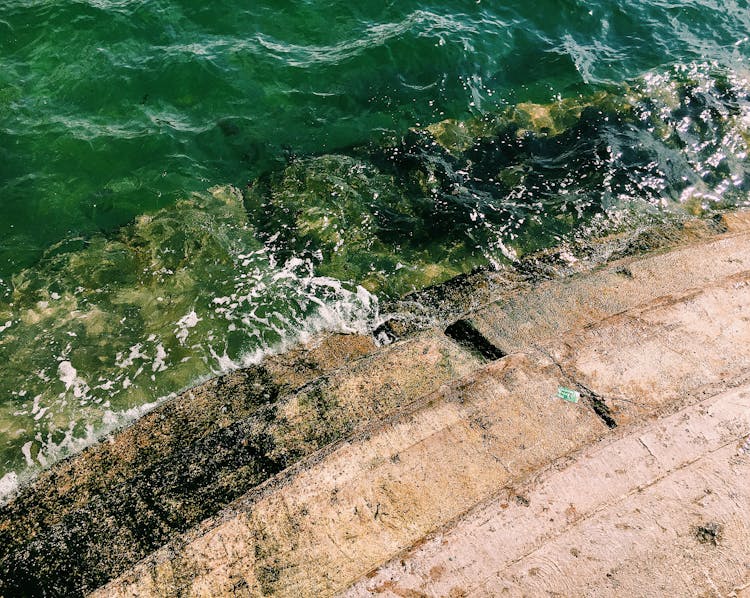 Stone Steps Near Rippling Foamy Ocean In Daylight