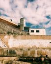 Rocky ground near fence and building with railing
