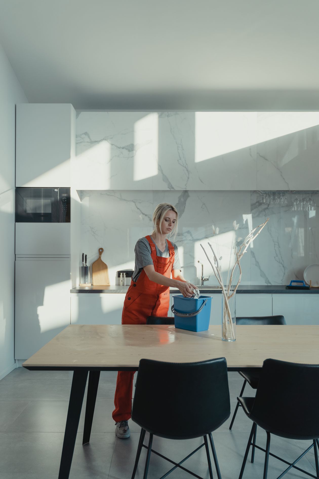Mulher de uniforme a limpar uma cozinha
