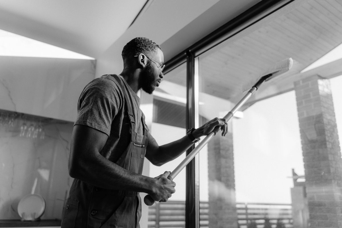 Professional cleaner cleaning an office glass panel