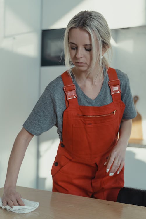 A Woman Wiping a Wooden Table