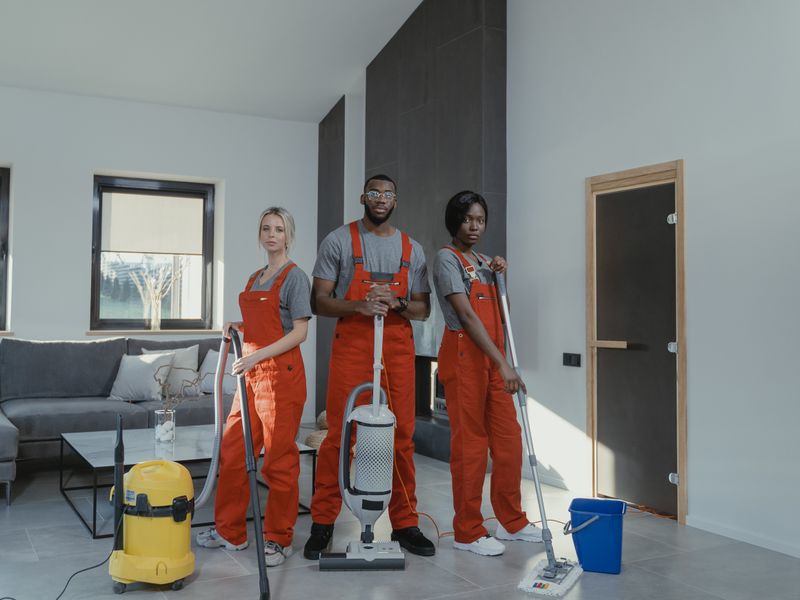 Commercial cleaning crew vacuuming and mopping an open office floor after hours