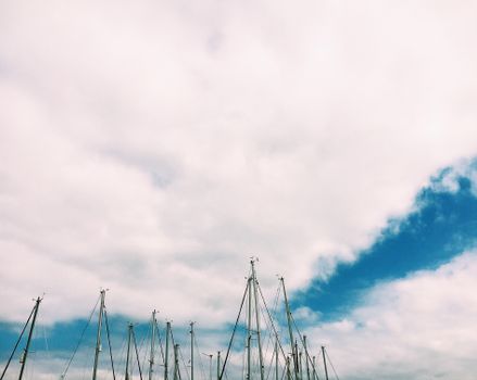 Sailboats with deflated sails under cloudy sky