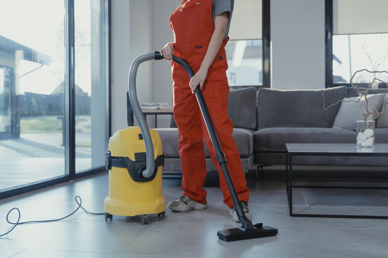 Cleaner vacuuming a living room floor