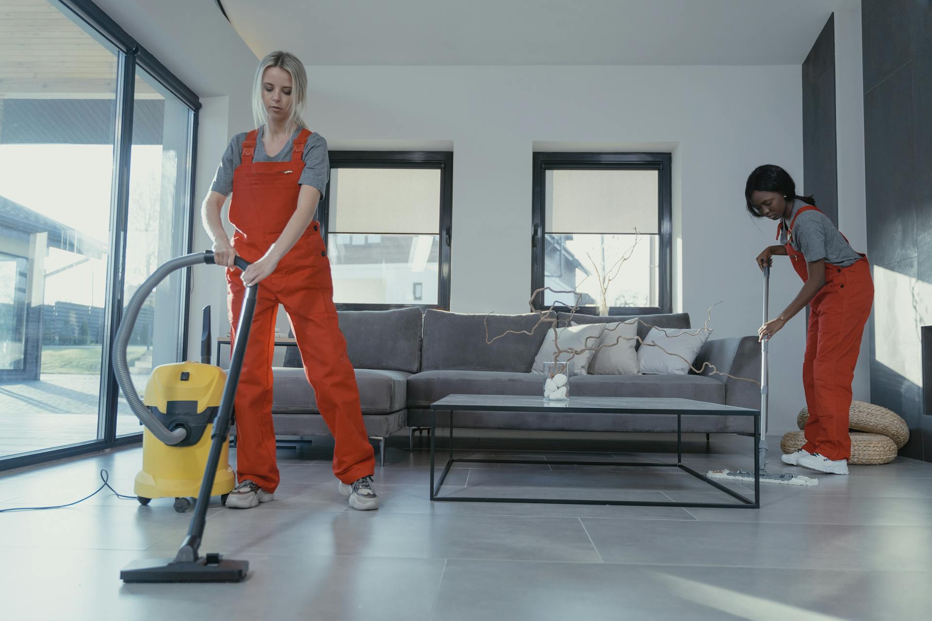 Women in Orange Uniform Cleaning the Floor