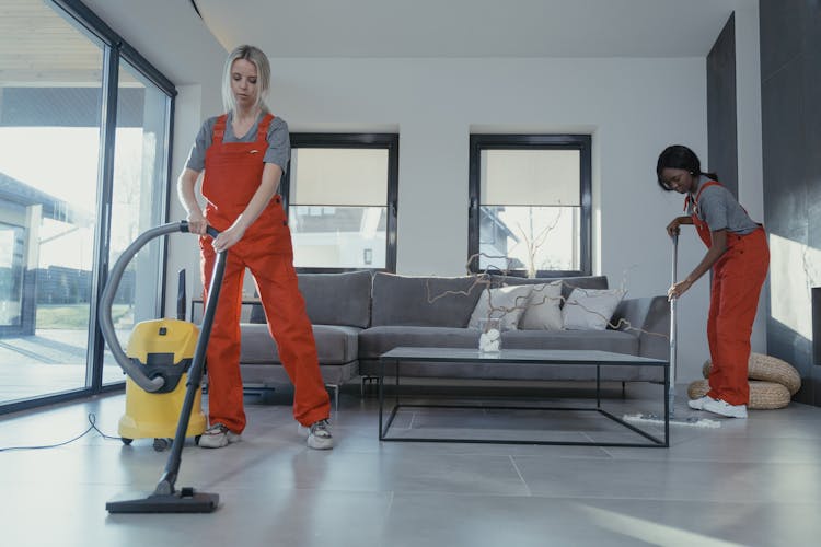 Women In Orange Uniform Cleaning The Floor