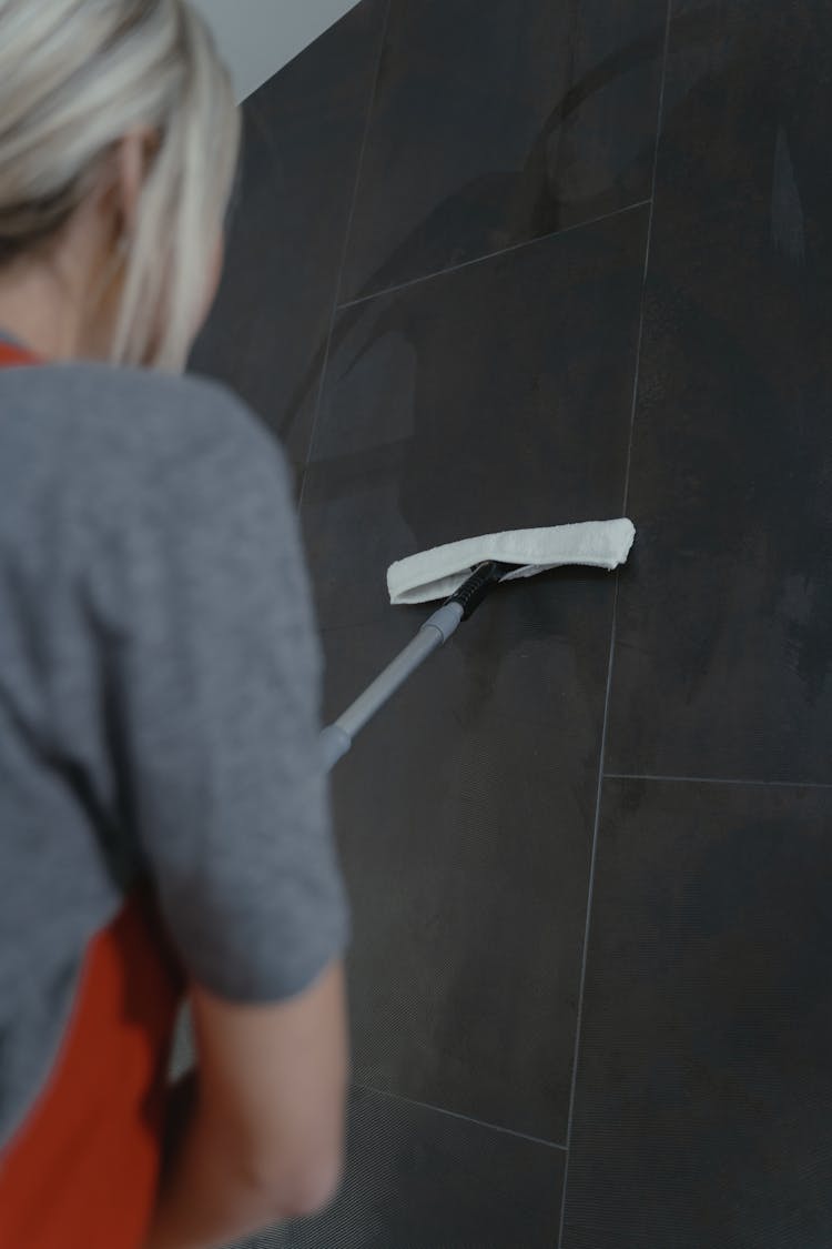 A Woman Cleaning A Wall