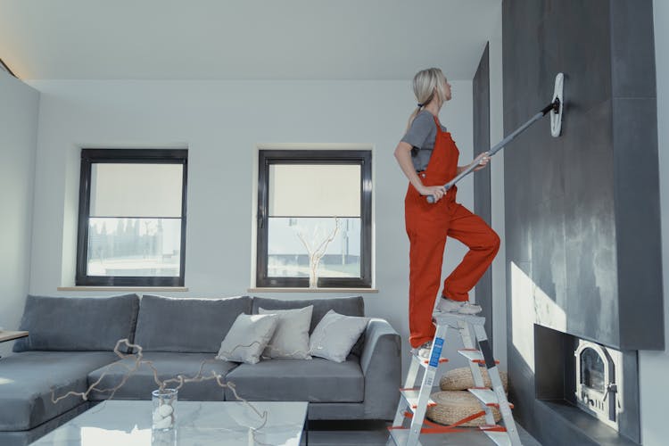 Woman Cleaning The Wall With A Mop