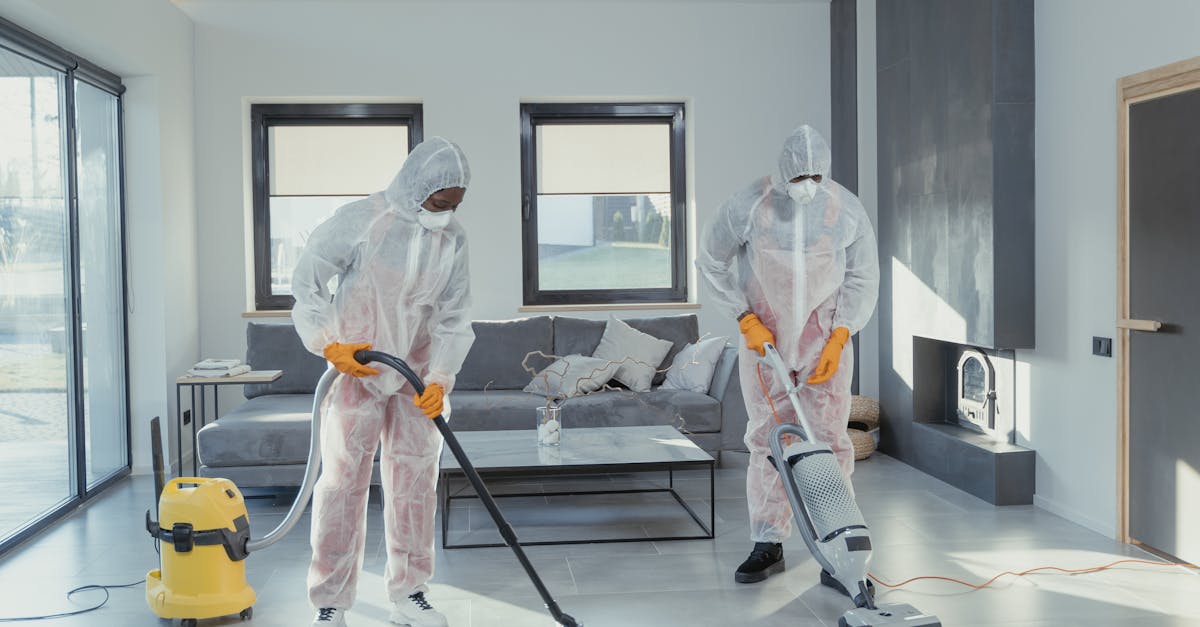 Cleaners in PPE Vacuuming a Tiled Floor
