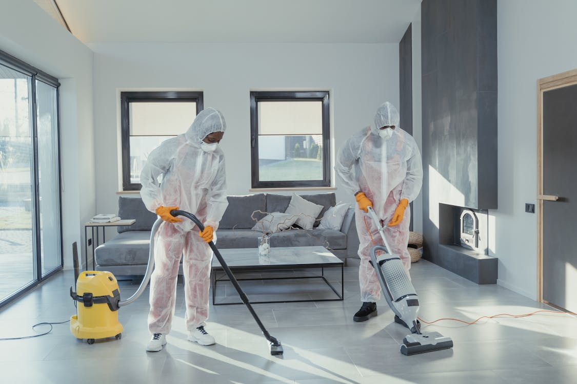 Free Cleaners In Ppe Vacuuming A Tiled Floor Stock Photo