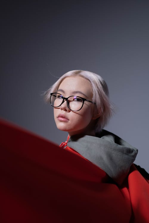 A Girl in Glasses Wearing a Red Cape