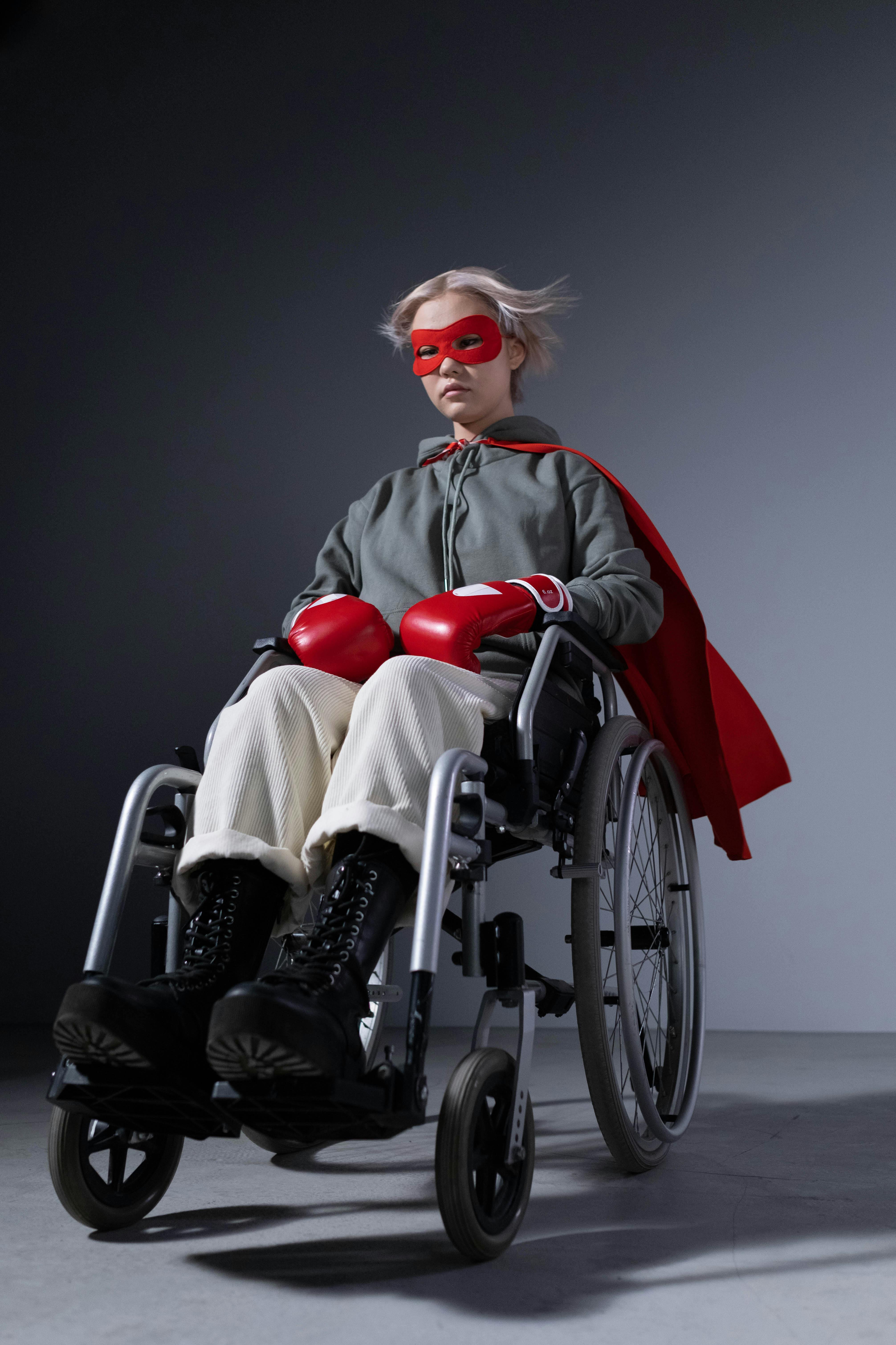 teenage girl wearing boxing gloves sitting on wheelchair