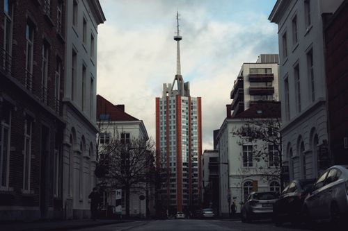 Free A glimpse of Sint-Maartensdal Tower amidst city buildings in Leuven, Belgium. Stock Photo
