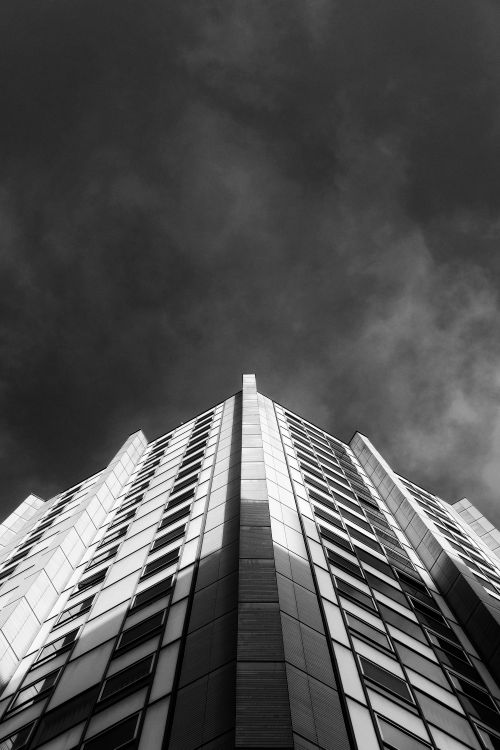 Free Striking low-angle black-and-white photo of a skyscraper against a dark sky in Leuven, Belgium. Stock Photo