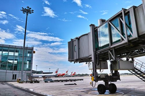 Free A jet bridge connects an aircraft at a busy airport on a clear day. Stock Photo