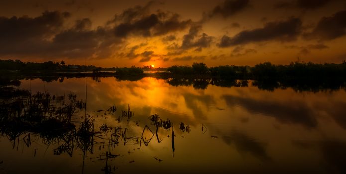 Beautiful sunset sky reflecting on a calm lake, creating a peaceful evening scene.