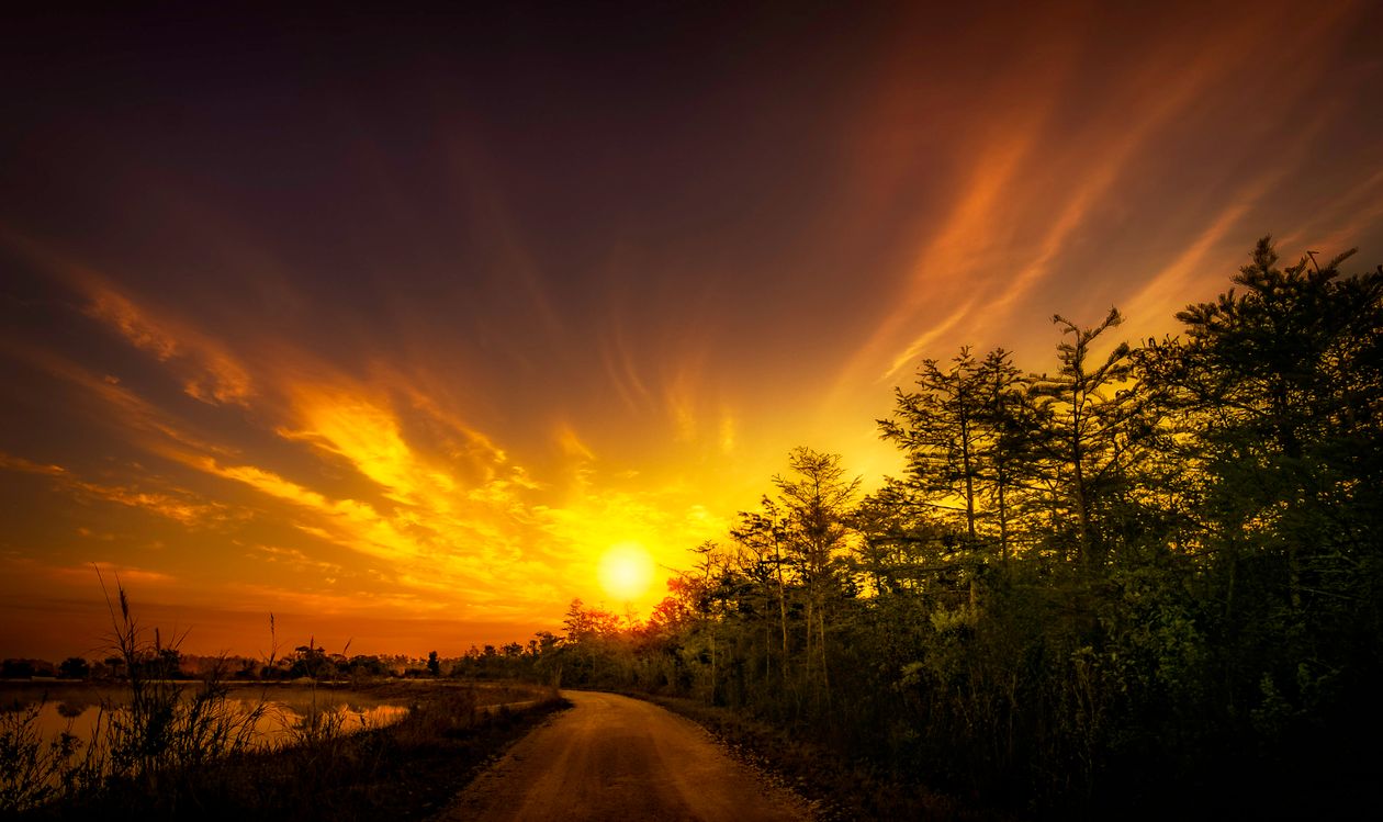 Dramatic Sunset Over Rural Road · Free Stock Photo