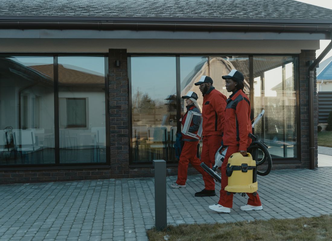Cleaning team with supplies approaching an office building