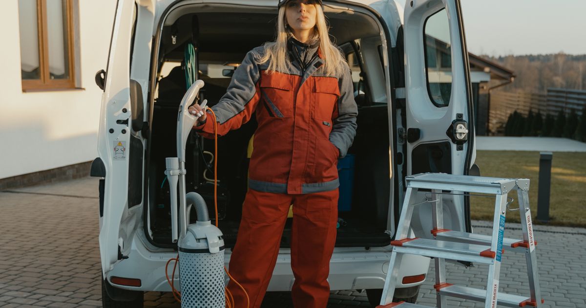 Reinigungskraft mit Ausrüstung am Fahrzeug in der Abendsonne – nebenberuflich eine Reinigungsfirma gründen