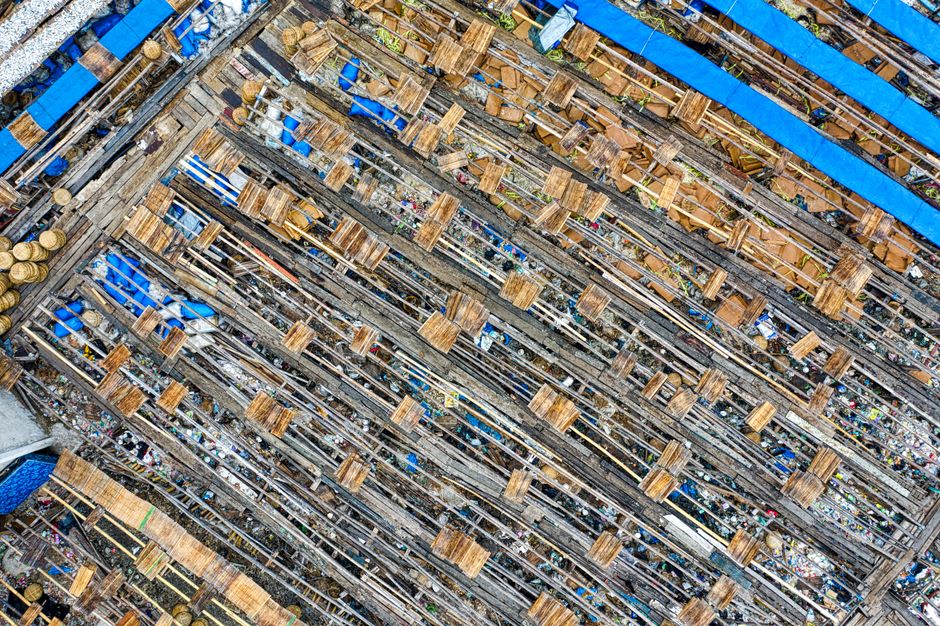 Aerial view of used cardboard boxes in rows in landfill in poor settlement